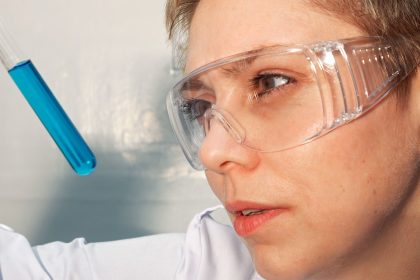 γυναίκα κοιτάζει τον εργαστηριακό σωλήνα επιστήμονες