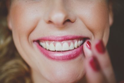 ουλίτιδα αντιμετώπιση γυναίκα στον οδοντίατρο με λευκά δόντια