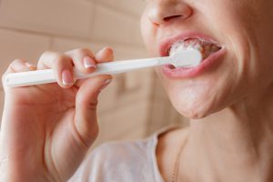 γυναικα βουρτσίζει τα δόντια της για στοματική υγεία