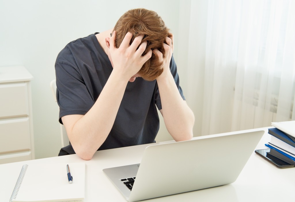 άνδρας με προβλήματα ψυχικής ασθένειας κρατάει το κεφάλι του