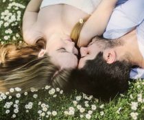 demisexual ζευγάρι είναι ξαπλωμένο στο χορτάρι και φιλιέται
