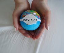 παραλλαγμένο στέλεχος covid19 σε υδρόγειο σφαίρα στα χέρια γυναίκας