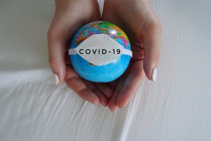 παραλλαγμένο στέλεχος covid19 σε υδρόγειο σφαίρα στα χέρια γυναίκας