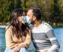 άνδρας και γυναίκα που φιλιούνται με μάσκα