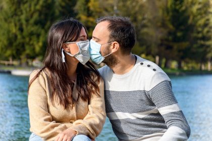 άνδρας και γυναίκα που φιλιούνται με μάσκα