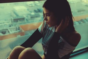 μελαγχολική κατάθλιψη γυναίκα κάθεται στο τζάμι στεναχωρημένη