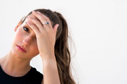 ορμονική ημικρανία περίοδο γυναίκα πιάνει το κεφάλι της που πονάει