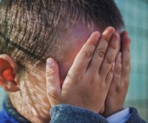παιδική κακοποίηση παιδί κλαίει και κρύβει το πρόσωπό του