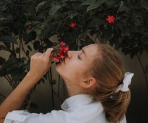 γυναίκα προσπαθεί να μυρίσει τα λουλούδια λόγω εμμένουσας ανοσμίας