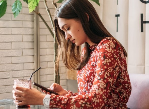 κοπέλα κοιταζει εφαρμογή γνωριμιών στο κινητό για περιστασιακό σεξ