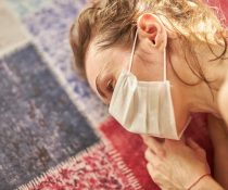 ψυχολογικά προβλήματα πανδημία γυναίκα με μάσκα ξαπλώνει στο πάτωμα