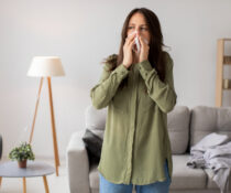 γυναίκα φτερνίζεται απο εποχικές αλλεργίες